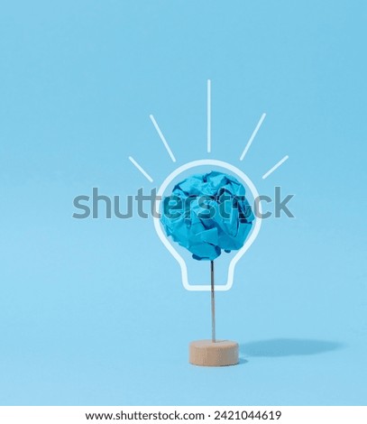 A crumpled ball of blue paper, a drawn electric lamp. New idea concept