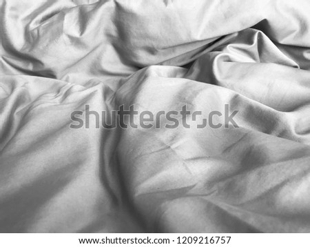 Crumpled blanket, bed sheet after wake up early in the morning. Wrinkled messy fabric for abstract wallpaper, cover and background.