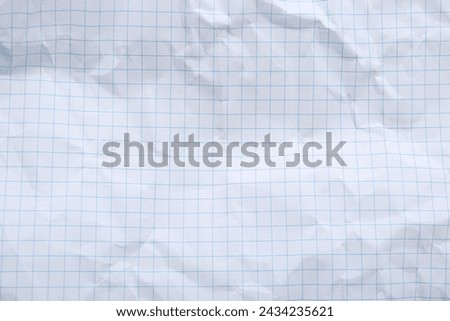 Crumpled checkered notebook sheet as background, top view