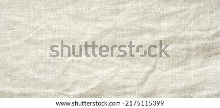 crumpled natural flaxen fabric, top view, linen textile background