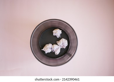 Crumpled Paper Ball In A Bin On A Light Purple Background 