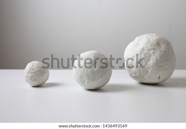 Crumpled paper ball on white. White balls of\
papier mache, similar to the planet. Fantasy paper balls.\
Lightweight textural\
balls.