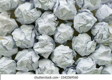 Crumpled Paper Balls Grouped Together On A Table. Design Concept For Creativity, Mental Or Writer's Block, Failed Plans, Unsuccessful Ideas, Frustrated But Persist In Working Towards Objective.