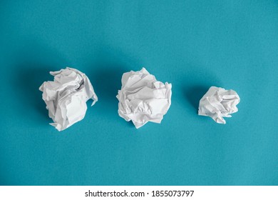 Crumpled paper balls on a blue background. Minimalist concept. Top view. Copy, empty space for text