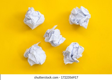 Crumpled paper balls on a yellow background