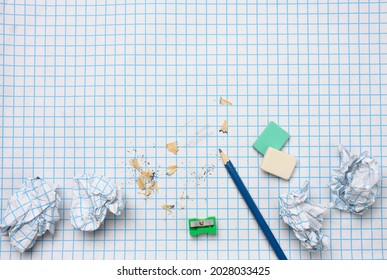 crumpled paper balls and a sharpened wooden pencil with shavings on a checkered paper sheet - Powered by Shutterstock