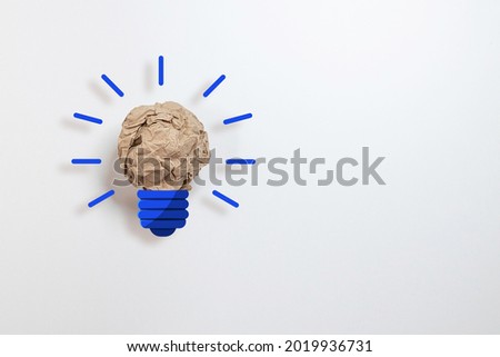 Crumpled paper light bulb unrealistic subject with copy space on white background