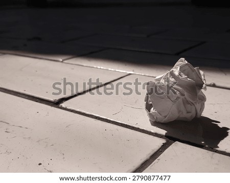 Crumpled paper on the floor with dramatic light and shadow, symbolizing sadness, frustration, and losing hope.