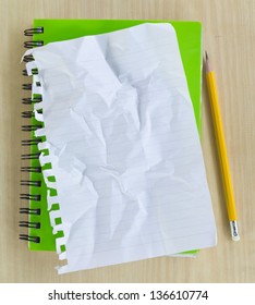 Crumpled Paper On Green Notebook