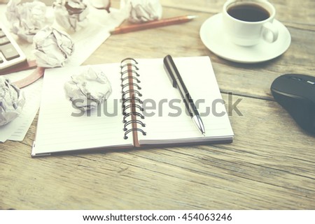 crumpled paper and  pen on notebook and  coffee on the table