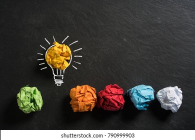 crumpled paper symbolizing different solutions with one standing out on a slate background
