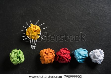 crumpled paper symbolizing different solutions with one standing out on a slate background