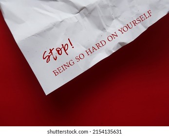 Crumpled paper with text STOP! BEING SO HARD ON YOURSELF - concept of our own worst critics, negative criticism  to our  flaws and mistakes by developing approach of self-compassion and kindness