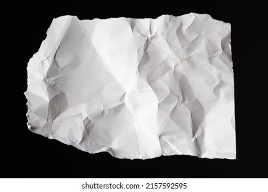 Crumpled paper. White piece of paper. Antique leaf torn from wallpaper on black background. Crumpled white parchment. Parchment for writing. Fragment torn form. Empty parchment. Copy space