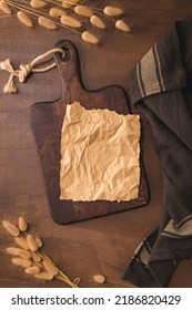 Crumpled Paper And Wooden Cutting Board On Brown Moody And Rustic Kitchen Countertop.