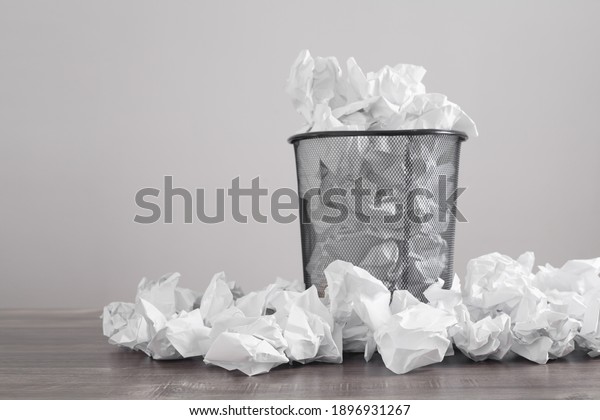 Crumpled papers in the trash\
can.