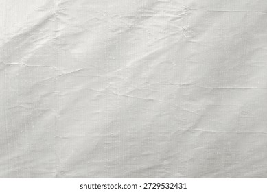 ​White crumpled plastic texture background with subtle woven pattern. Grungy wrinkled synthetic fabric surface, abstract industrial tarp material for overlay or backdrop design.