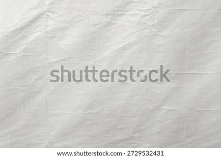 ​White crumpled plastic texture background with subtle woven pattern. Grungy wrinkled synthetic fabric surface, abstract industrial tarp material for overlay or backdrop design.