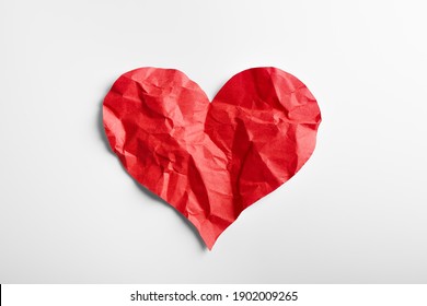Crumpled red heart shape paper isolated on white background. Broken heart concept.
