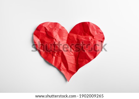 Crumpled red heart shape paper isolated on white background. Broken heart concept.