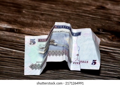 Crumpled Saudi Arabia money of 5 SAR five riyals isolated on wooden background, wrinkled 5 Saudi Riyals cash bill banknote, Saudi money inflation and economy world crisis concept, selective focus