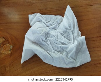 A Crumpled Tissue On A Wooden Background