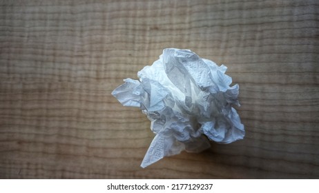 Crumpled Tissue Paper On The Table. Tissue Ball On Wooden Table. 