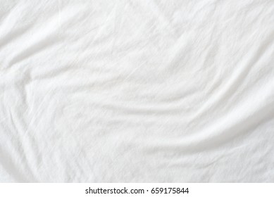 Crumpled White Bed Sheet In A Hotel / Hostel Room. The Manufacturing Of Bedsheet Uses Cotton And Cotton Blends, Polyester And Others Fibers Such As Linen, Silk Modal And Bamboo Rayon, Lyocell, Etc.