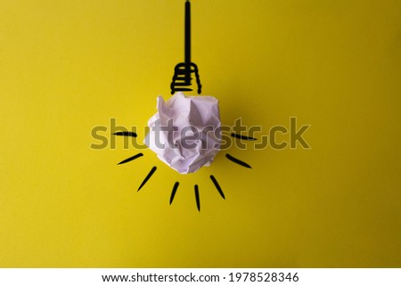 Crumpled white sheet composing lamp on yellow background.