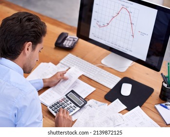 Crunching The Numbers. Rearview Shot Of A Handsome Young Businessman Working At His Desk.