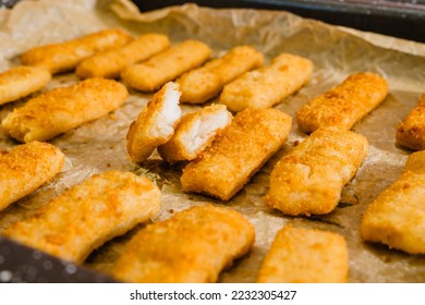 Crunchy breaded fish sticks made from wild caught Alaskan Pollock close-up on a baking pan, just from the oven - Shutterstock ID 2232305427