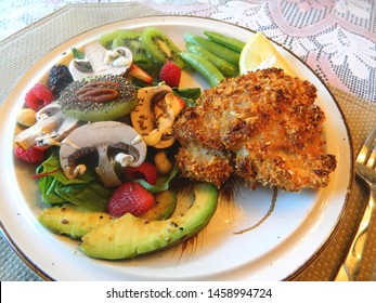 crunchy chicken thigh on a plate with salad
					