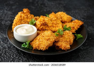 Crunchy cornflakes Chicken with mustard honey sauce on black plate