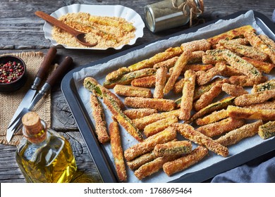 crunchy zucchini sticks breaded with panko breadcrumbs, parmesan cheese, spices on a baking tray, Healthy summer snack, close-up. landscape view