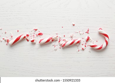 Crushed Candy Cane On White Wooden Background, Flat Lay. Traditional Christmas Treat