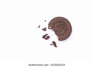 Crushed Chocolate Cookie With Vanilla Cream In The Middle Of Cookies With Crumbs And Small Pieces Of Cookie All Around Separated On The White Background.