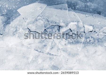 Crushed ice surface background texture with cracks in a light-blue tone.