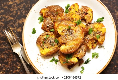 crushed potatoes. smashed potatoes. recipes for Australian cuisine. the potatoes are boiled in a shell, broken and baked in an oven with spices. top view