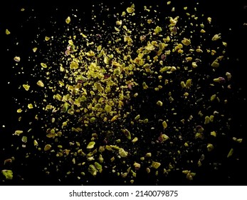 Crushed raw pistachio explosion on black background