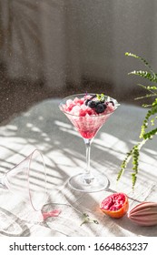 Crushed Red Ice In Martini Glass. Berry Granita With Mint And Blueberries. Harsh Light And Shadows. Natural Lighting. White Background. Sunlight With Large Shadows. Minimalist Food Photography.