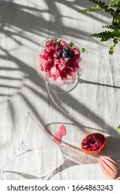 Crushed Red Ice In Martini Glass. Berry Granita With Mint And Blueberries. Harsh Light And Shadows. Natural Lighting. White Background. Sunlight With Large Shadows. Minimalist Food Photography.