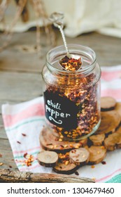 Crushed Red Pepper Flakes In A Shaker On A Wooden Table.Selective Focus.Toning.