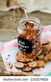 Crushed Red Pepper Flakes In A Shaker On A Wooden Table.Selective Focus.