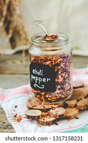 Crushed Red Pepper Flakes In A Shaker On A Wooden Table.Selective Focus.Toning.