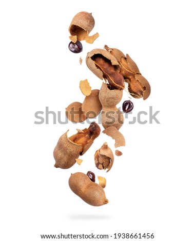 Crushed tamarind fruits are falling down on white background
