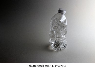 Crushed Water Bottle With Dark Grey Background.