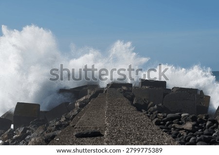 Crushing ocean wave colliding with massive coastal breakwater, capturing the raw power and explosive energy of naure