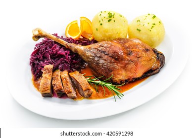 Crusty goose leg with braised red cabbage and dumplings isolated on white