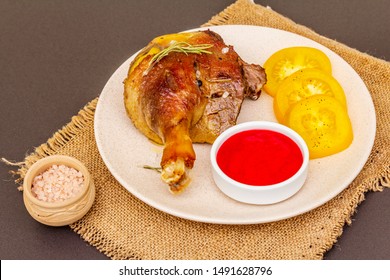 Crusty roasted duck leg. Traditional French food confit preparation. Served with cranberry sauce, fresh tomatoes, dry rosemary. Animal proteins, healthy fats. Stone background close up - Shutterstock ID 1491628796