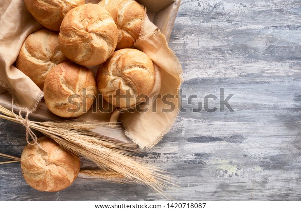 Crusty\
round bread rolls, known as Kaiser or Vienna rolls on linen towel,\
flat lay on rustic background with text\
space